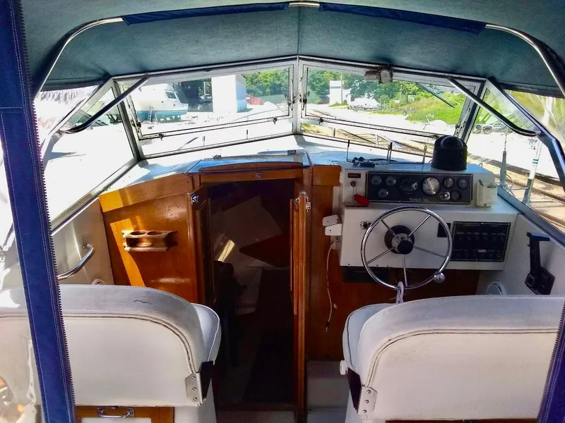 Slide: The Image of 1987 Hinterhoeller Limestone Express boat interior with steering wheel and cabin entrance. - 7