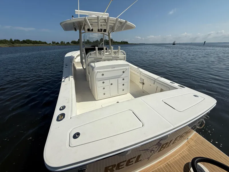 Slide: The Image of 2018 Regulator 31 boat on calm water, featuring spacious deck and center console. - 10