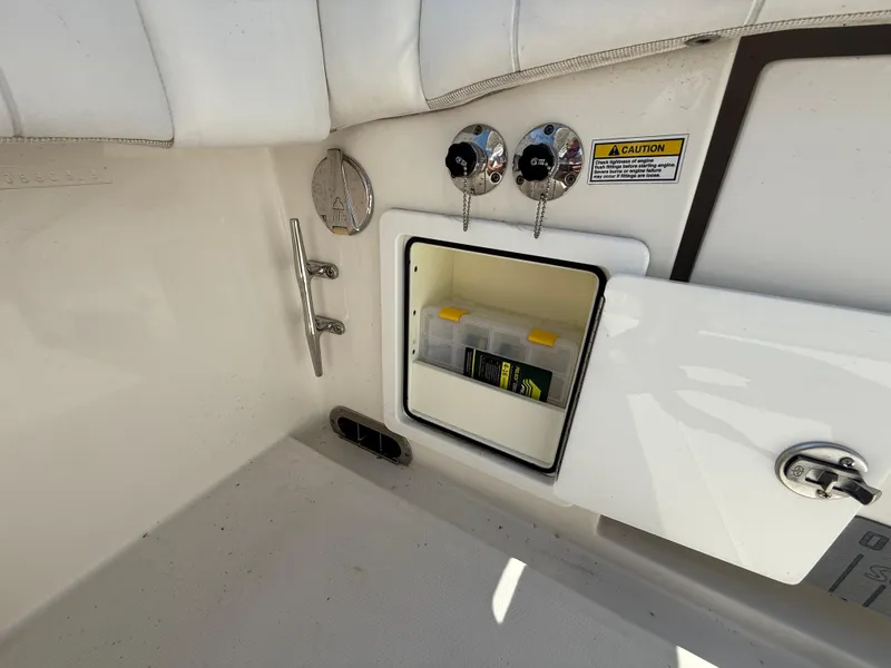 Slide: The Image of 2018 Regulator 31 boat storage compartment with safety warning and equipment inside. - 14