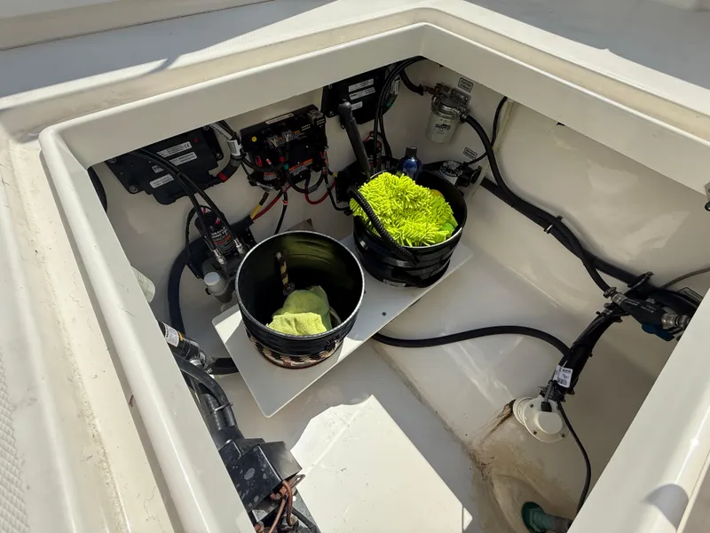 Slide: The Image of 2018 Regulator 31 boat storage compartment with cleaning supplies and wiring. - 17