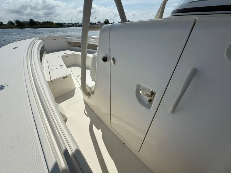 Slide: The Image of 2018 Regulator 31 boat interior with seating and storage, on a sunny day by the water. - 26