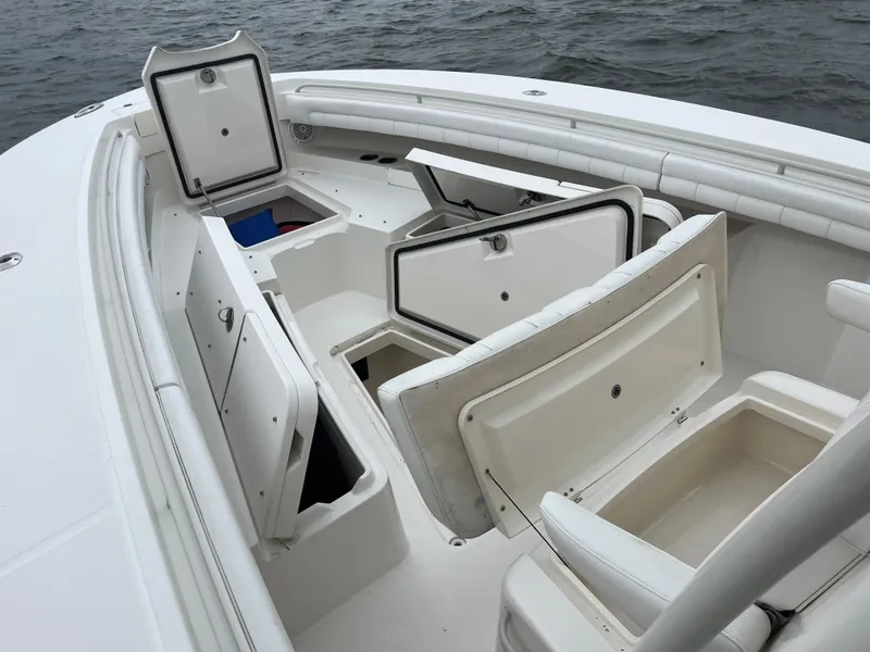 Slide: The Image of 2018 Regulator 31 boat with open storage compartments on deck, near water. - 30