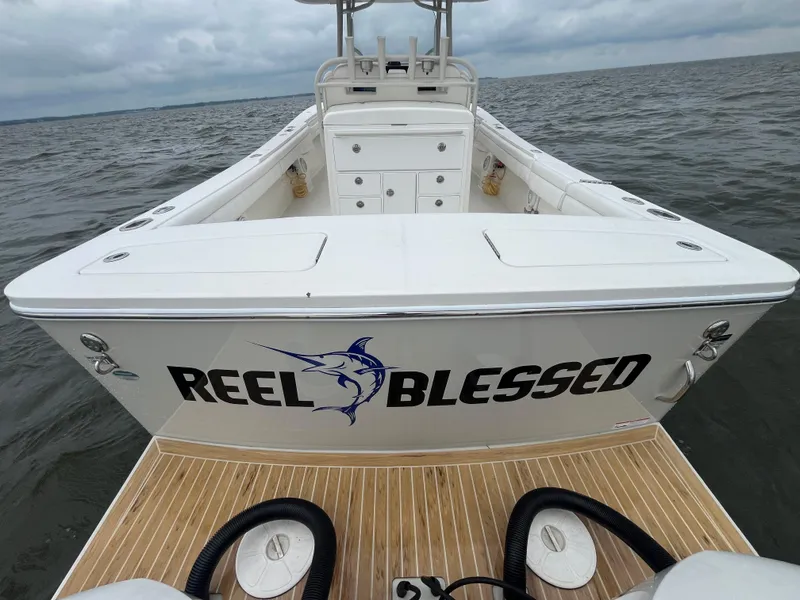 Slide: The Image of 2018 Regulator 31 boat named "Reel Blessed" on water, cloudy sky background. - 9