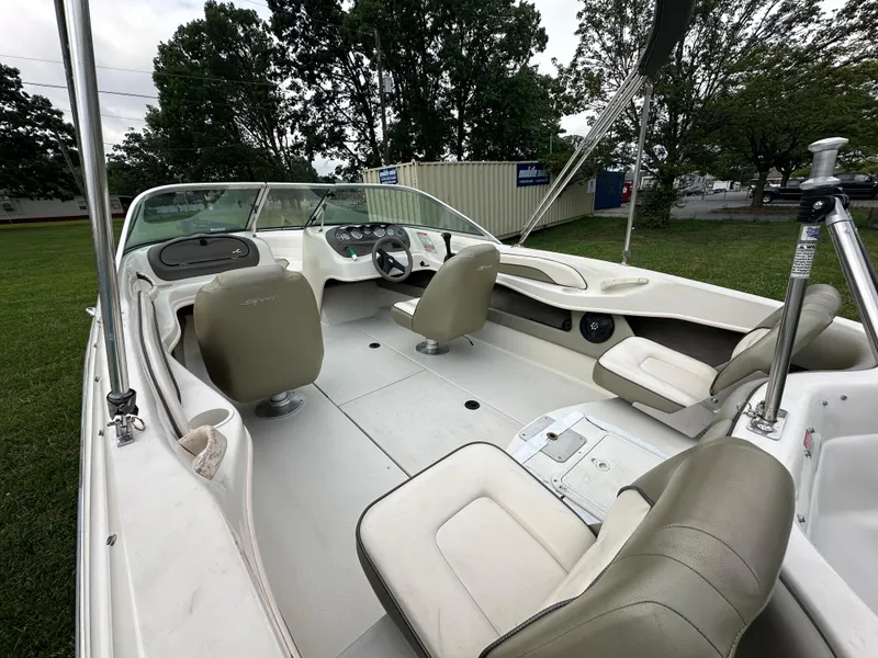 Slide: The Image of 2005 Sea Ray 185 Fish N Ski boat interior with beige seating and steering console. - 3