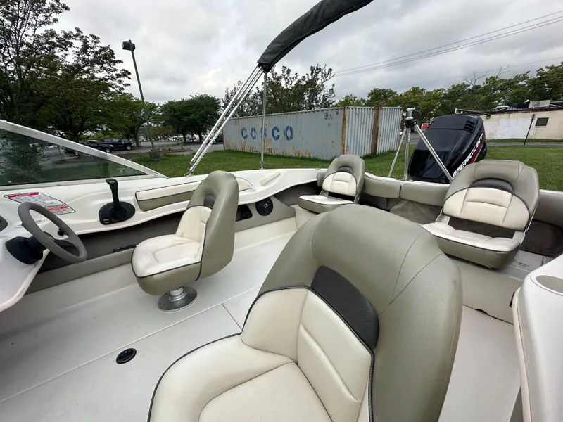 Slide: The Image of 2005 Sea Ray 185 Fish N Ski boat interior with beige seating and steering wheel. - 4