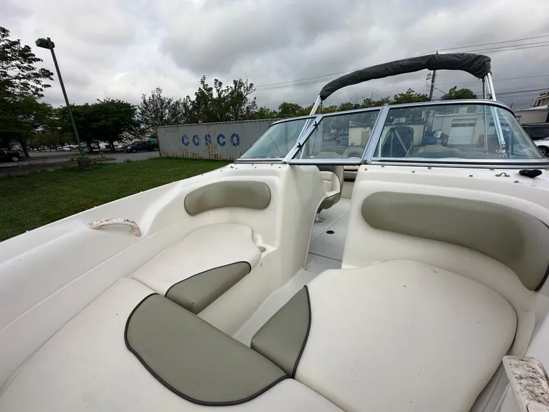 Slide: The Image of 2005 Sea Ray 185 Fish N Ski boat interior with cushioned seating and windshield. - 6