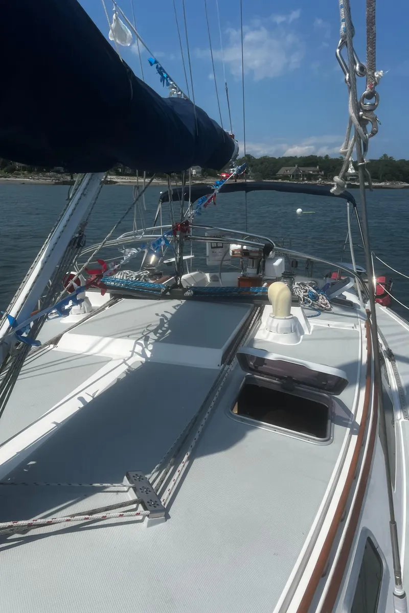Slide: The Image of 1990 Catalina 42 sailboat on calm water, clear sky, and visible deck details. - 18
