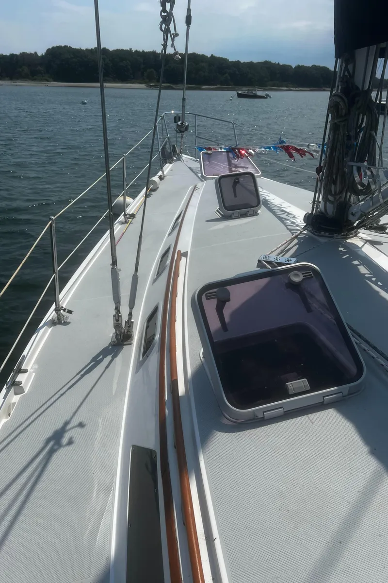 Slide: The Image of Sailboat deck of 1990 Catalina 42 on calm water, featuring open hatches and rigging. - 19