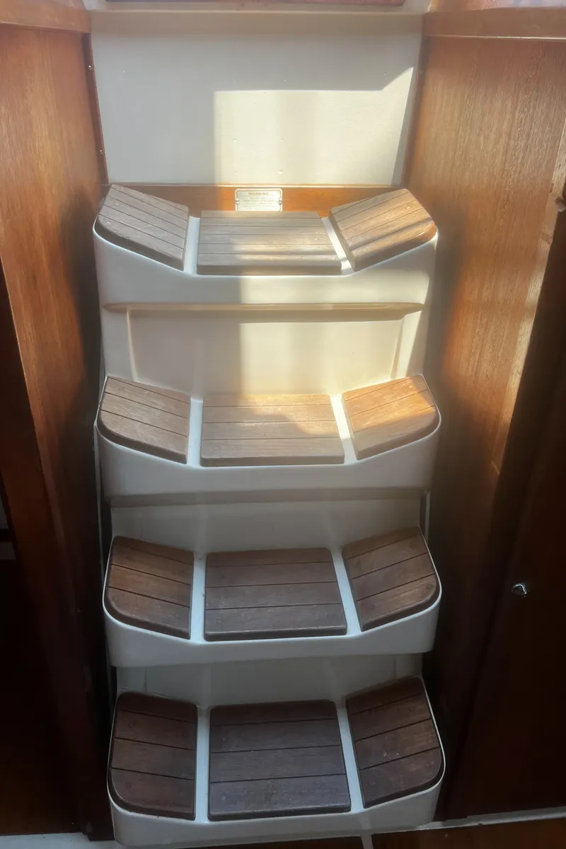 Slide: The Image of Wooden steps inside a 1990 Catalina 42 sailboat, featuring a compact, elegant design. - 21