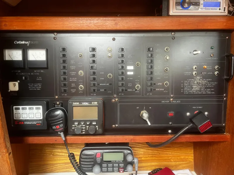 Slide: The Image of Control panel of a 1990 Catalina 42 sailboat with various switches and communication devices. - 29