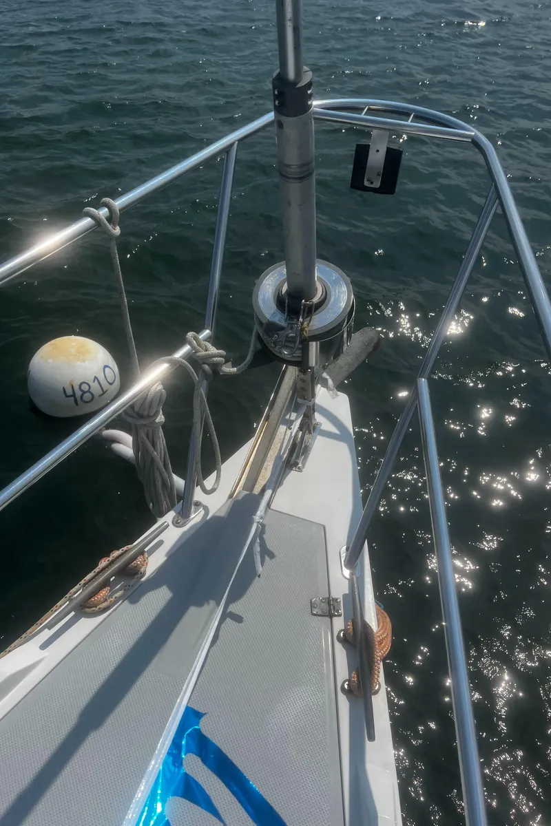 Slide: The Image of Bow of 1990 Catalina 42 sailboat on water with buoy nearby. - 6