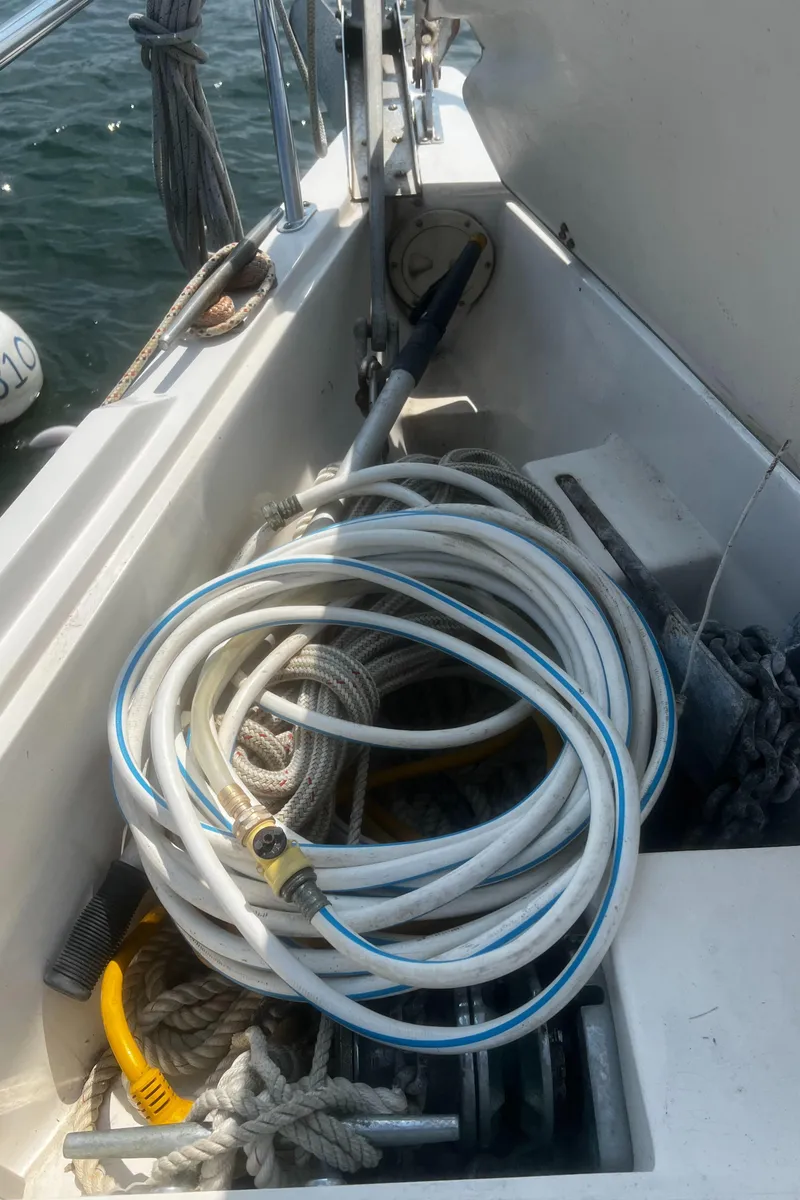 Slide: The Image of Coiled hose on 1990 Catalina 42 sailboat deck, near ropes and winch. - 7