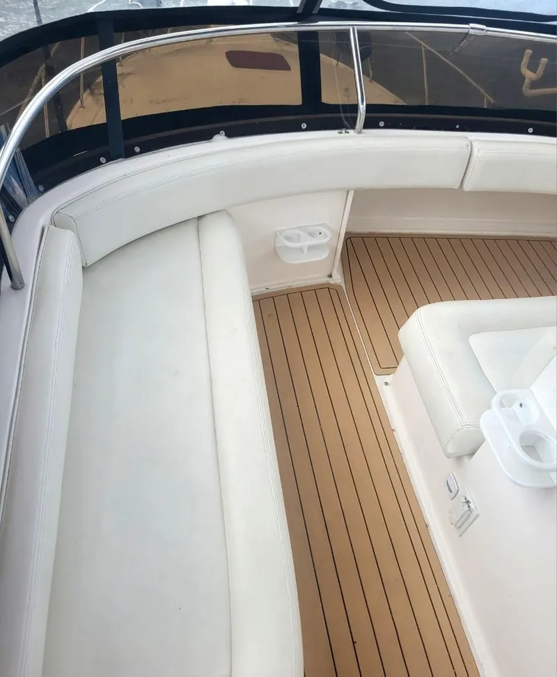 Slide: The Image of 1999 Silverton 37 Convertible boat interior with white seating and wooden flooring. - 21