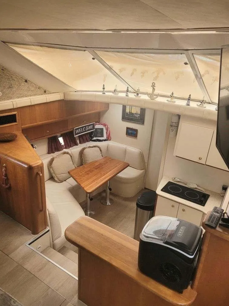 Slide: The Image of Interior of 1999 Silverton 37 Convertible yacht with cozy dining area and kitchenette. - 27