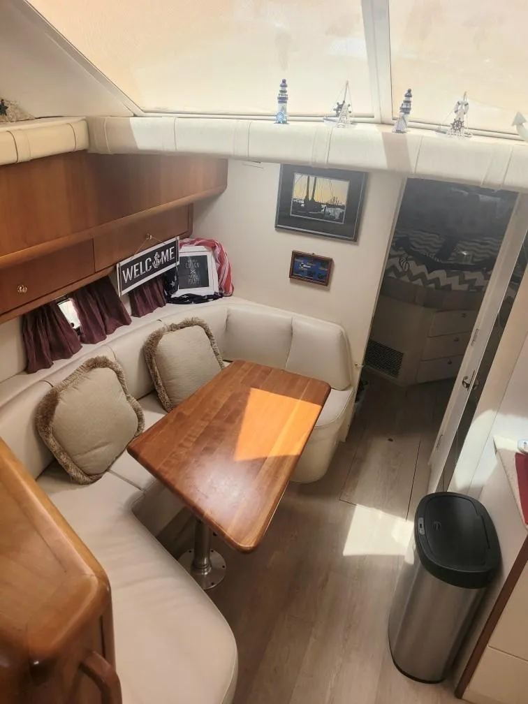Slide: The Image of Interior of 1999 Silverton 37 Convertible yacht with cozy seating and wooden table. - 35