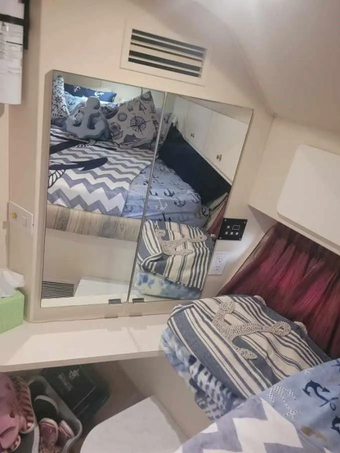 Slide: The Image of Interior of 1999 Silverton 37 Convertible with mirrored cabinet and cozy bedding. - 36