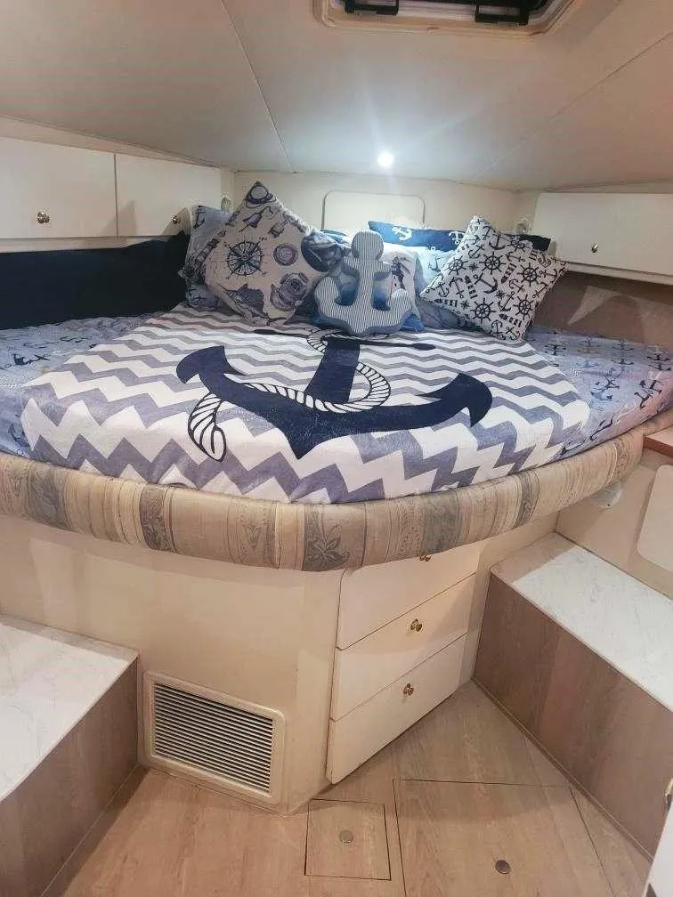 Slide: The Image of Cozy cabin interior of 1999 Silverton 37 Convertible with nautical-themed bedding. - 39