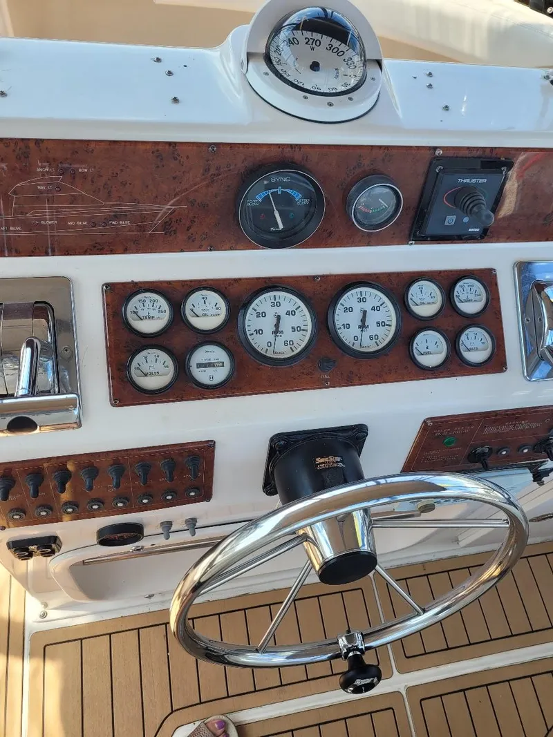 Slide: The Image of 1999 Silverton 37 Convertible boat dashboard with gauges and steering wheel. - 42