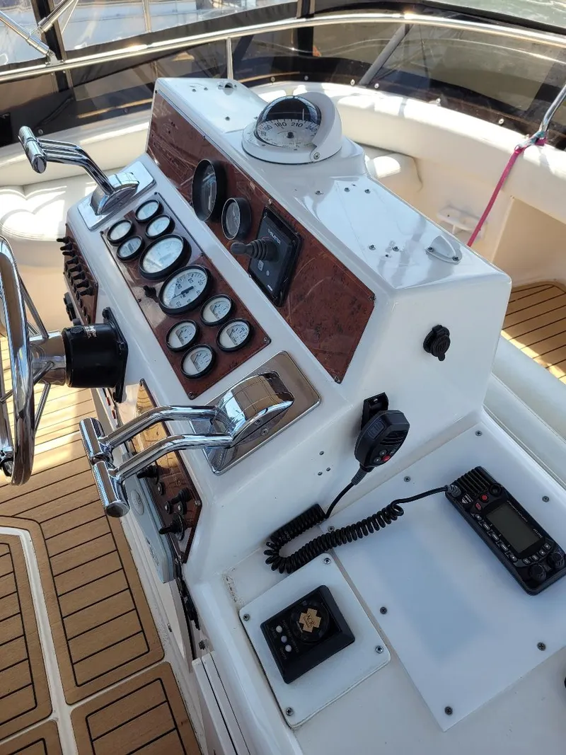 Slide: The Image of 1999 Silverton 37 Convertible boat helm with gauges and controls. - 44