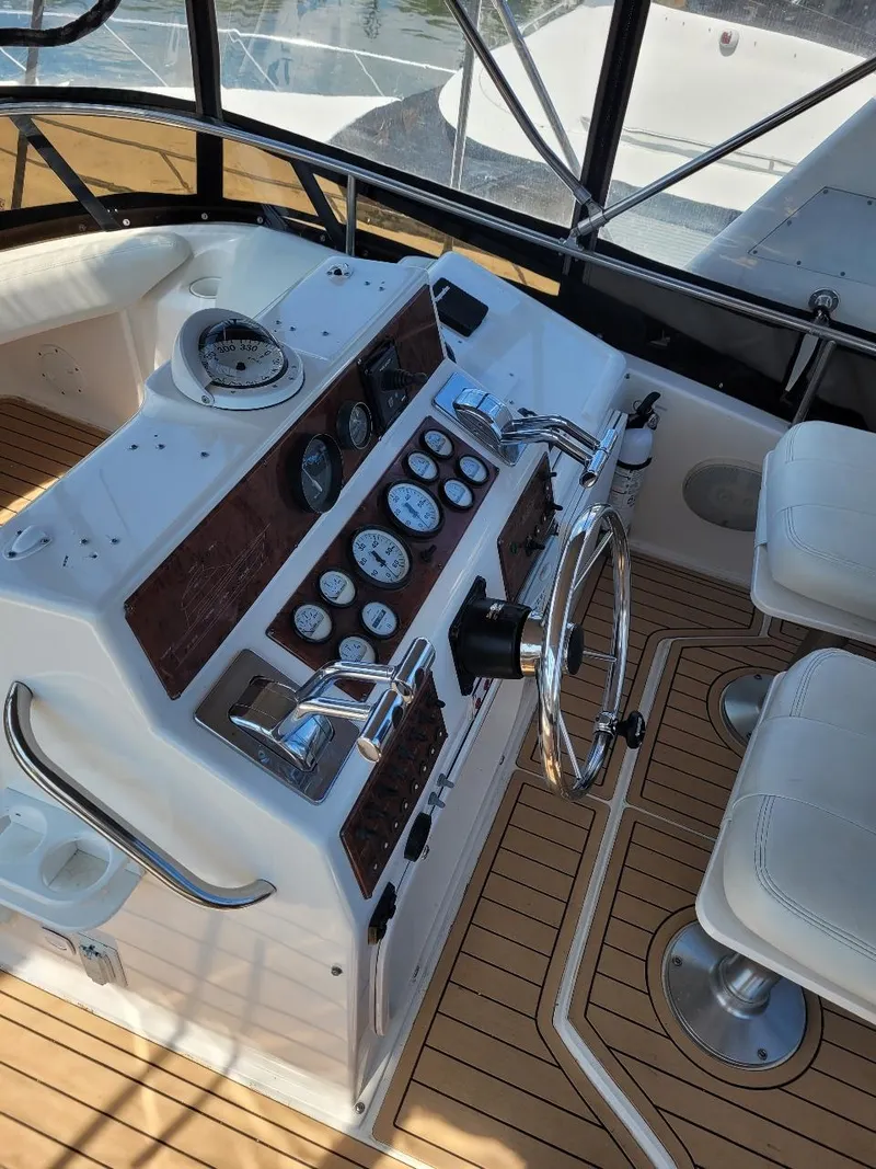 Slide: The Image of 1999 Silverton 37 Convertible boat cockpit with steering wheel and control panel. - 45