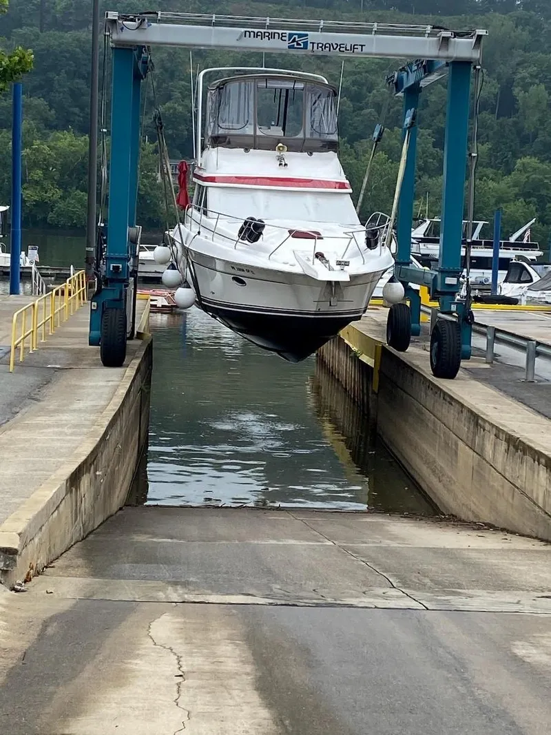 Slide: The Image of 1999 Silverton 37 Convertible boat being lifted by a marine travel lift. - 6