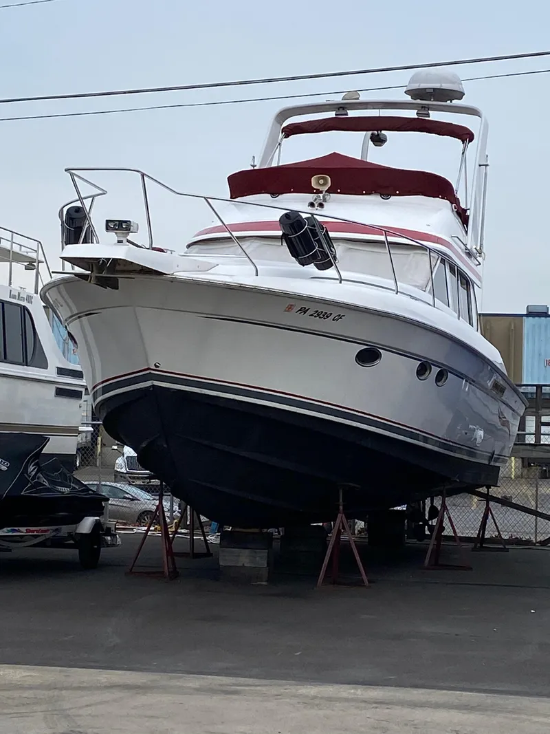 Slide: The Image of 1999 Silverton 37 Convertible yacht on dry dock, white hull, red accents. - 8