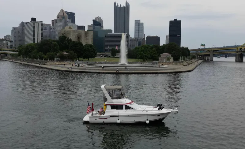 Slide: The Image of 1999 Silverton 37 Convertible yacht cruising near city skyline and fountain. - 9