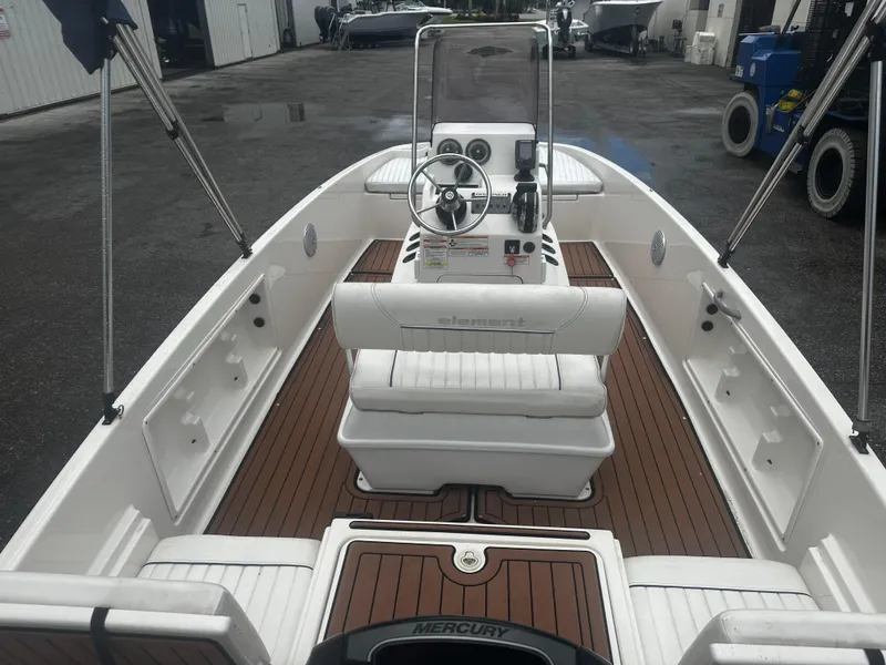 Slide: The Image of 2017 Bayliner Element F18 boat interior with wood deck and steering console. - 15
