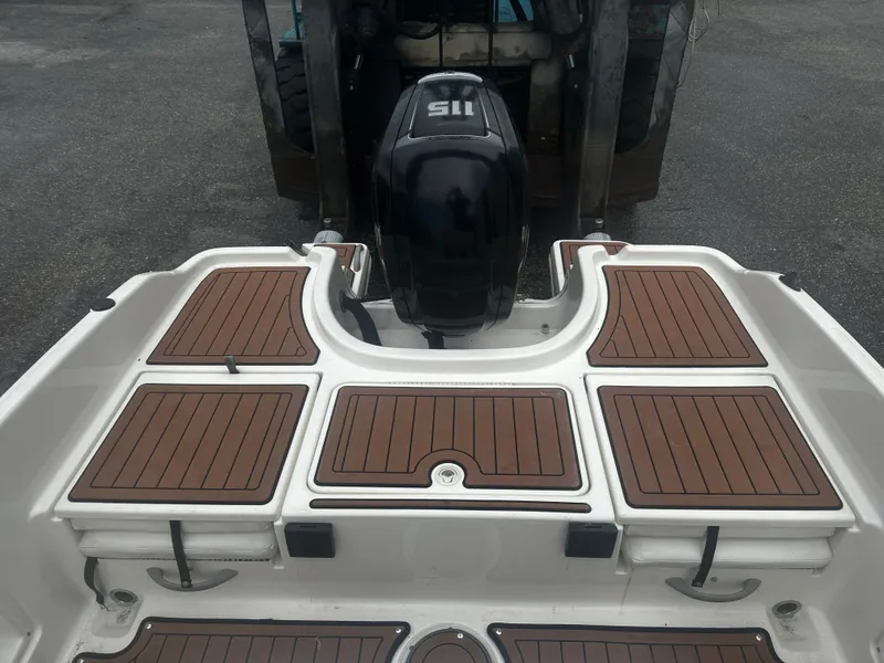 Slide: The Image of 2017 Bayliner Element F18 boat deck with wood paneling and outboard motor. - 16