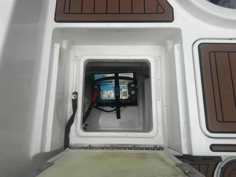 Slide: The Image of 2017 Bayliner Element F18 boat battery compartment with secure straps. - 18
