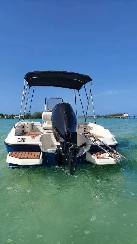 Slide: The Image of 2017 Bayliner Element F18 boat on clear water with blue sky. - 2