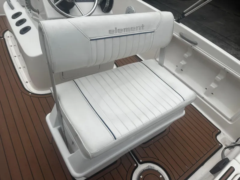Slide: The Image of 2017 Bayliner Element F18 boat seat with white upholstery and wood-style flooring. - 20