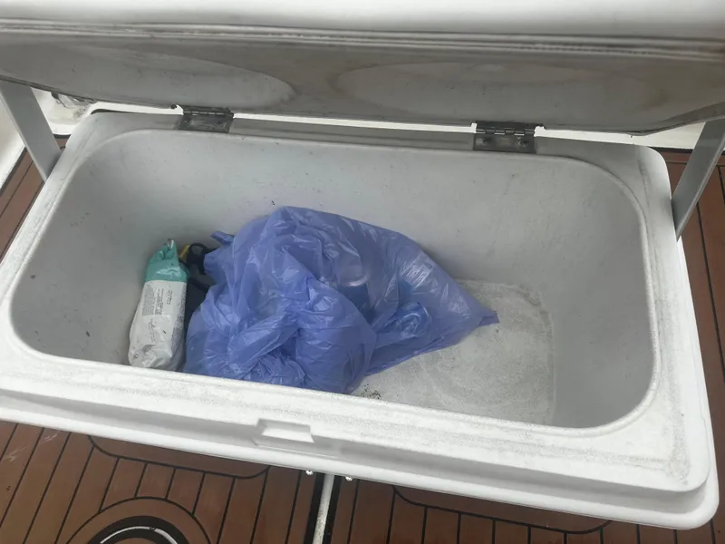 Slide: The Image of Open storage compartment on 2017 Bayliner Element F18 boat with items inside. - 22