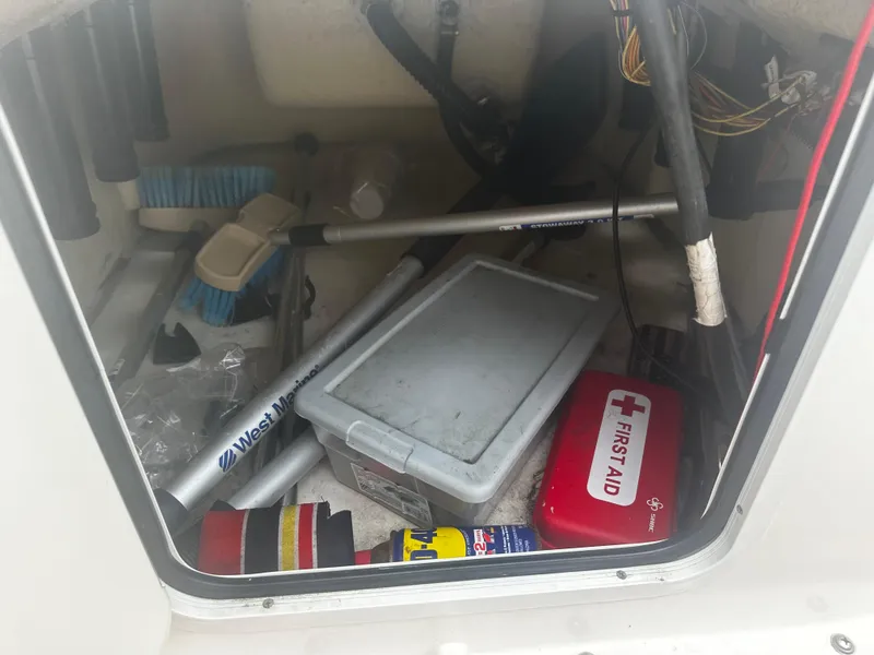 Slide: The Image of Storage compartment of 2017 Bayliner Element F18 with cleaning supplies and first aid kit. - 27