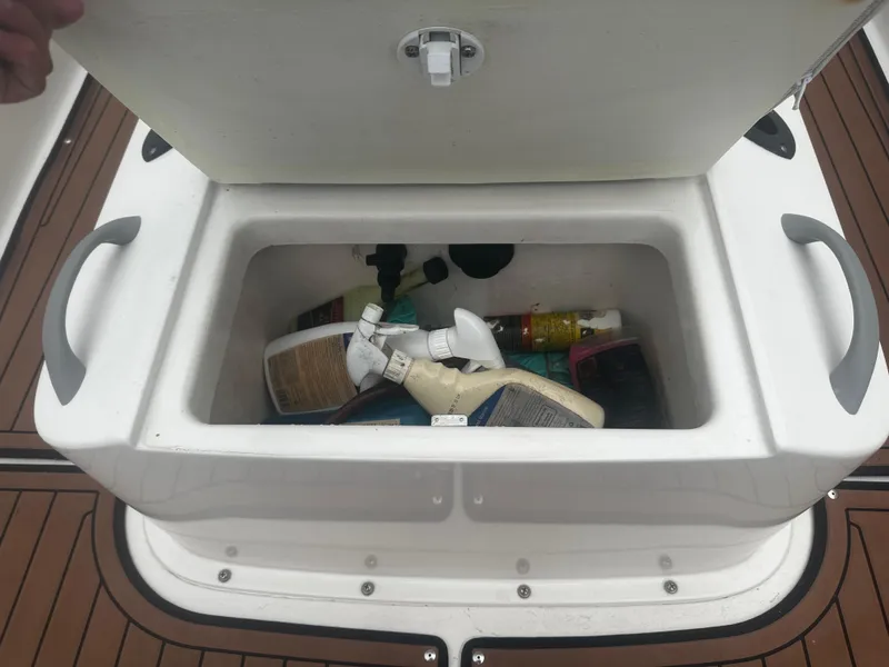 Slide: The Image of Open storage compartment on 2017 Bayliner Element F18 boat with cleaning supplies. - 31