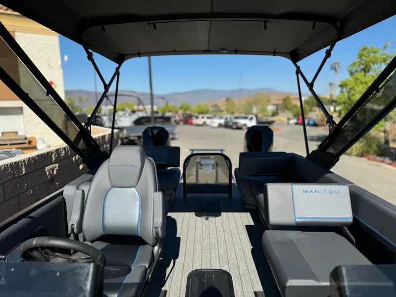 Slide: The Image of 2025 Manitou Explore 24 Switchback boat interior with trifold bench seating. - 11