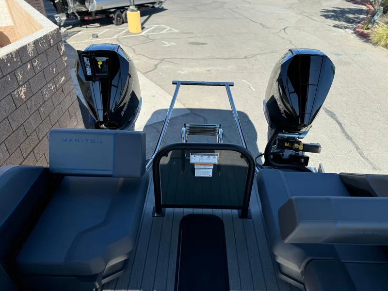 Slide: The Image of 2025 Manitou Explore 24 Switchback boat with dual engines and trifold bench seating. - 12