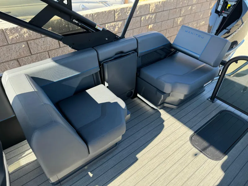 Slide: The Image of 2025 Manitou Explore 24 Switchback boat interior with dual SHP trifold bench seating. - 13