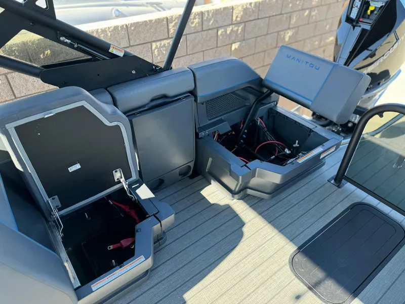 Slide: The Image of 2025 Manitou Explore 24 Switchback boat interior with open storage compartments. - 15