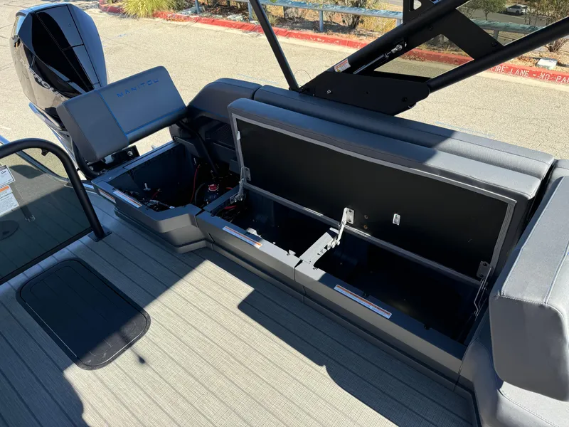 Slide: The Image of 2025 Manitou Explore 24 Switchback boat with open trifold bench storage compartments. - 16