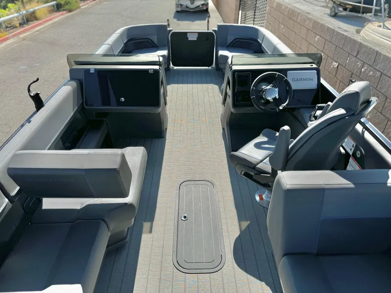 Slide: The Image of 2025 Manitou Explore 24 Switchback boat interior with trifold bench seating and Garmin navigation. - 18