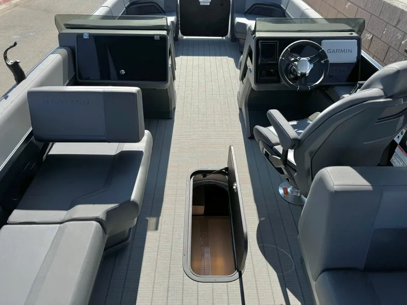 Slide: The Image of 2025 Manitou Explore 24 Switchback boat interior with trifold bench and Garmin navigation system. - 24