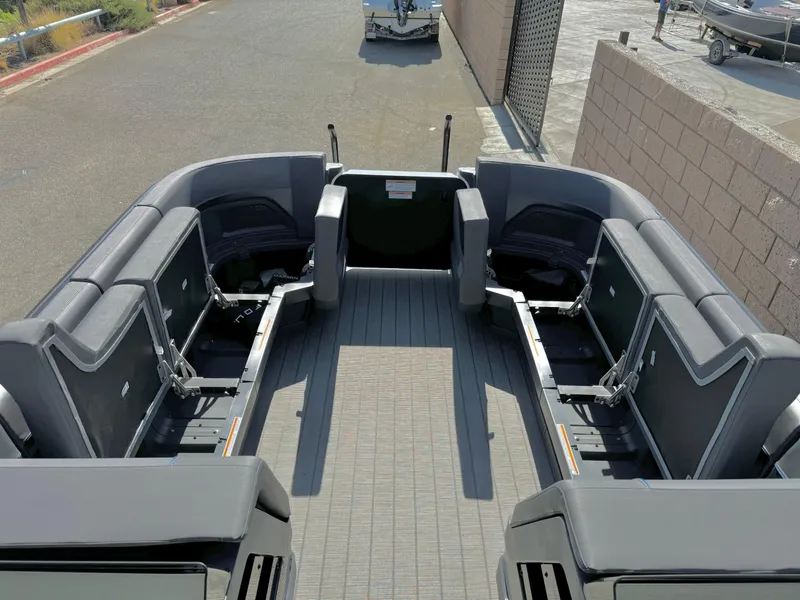Slide: The Image of 2025 Manitou Explore 24 Switchback boat with trifold bench seating, docked on a sunny day. - 25