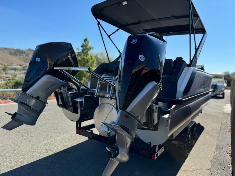 Slide: The Image of 2025 Manitou Explore 24 Switchback Dual SHP boat with trifold bench, rear view. - 6