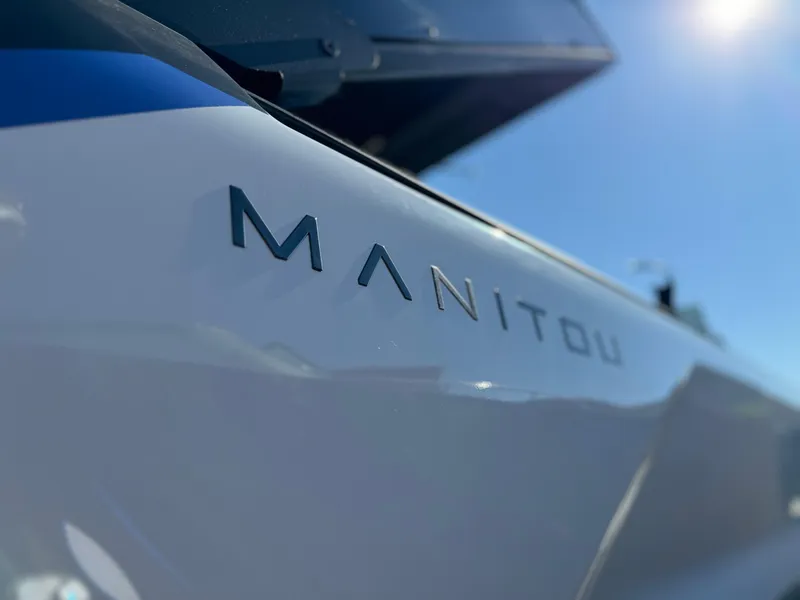 Slide: The Image of Close-up of 2025 Manitou Explore 24 Switchback boat with logo in sunlight. - 9