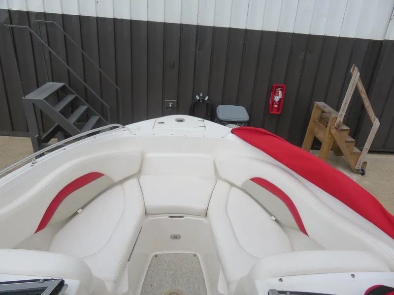 Slide: The Image of 2008 Chaparral SSX 236 boat interior with white and red seating, docked near stairs. - 13