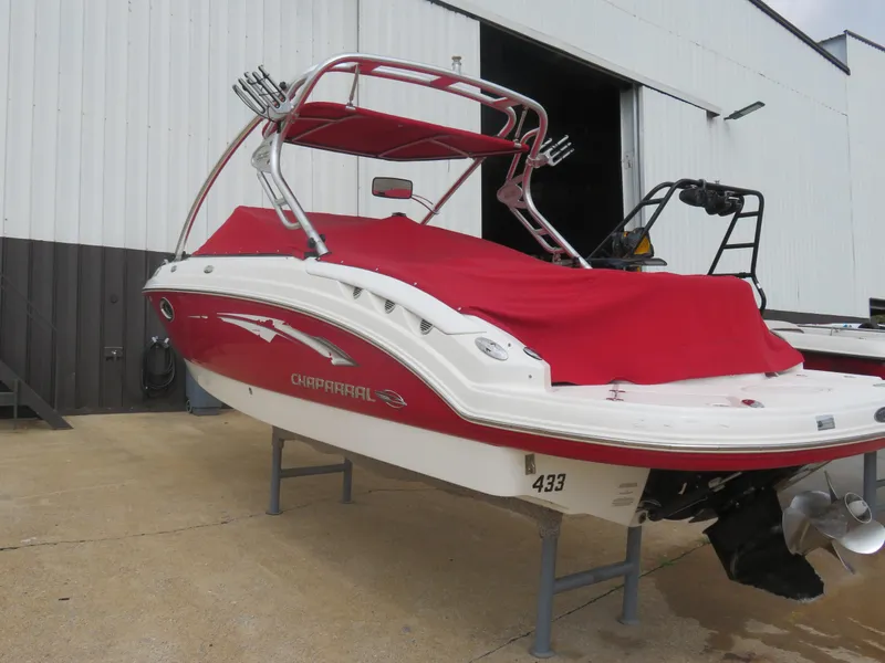 Slide: The Image of 2008 Chaparral SSX 236 boat with red cover, parked outside a warehouse. - 16