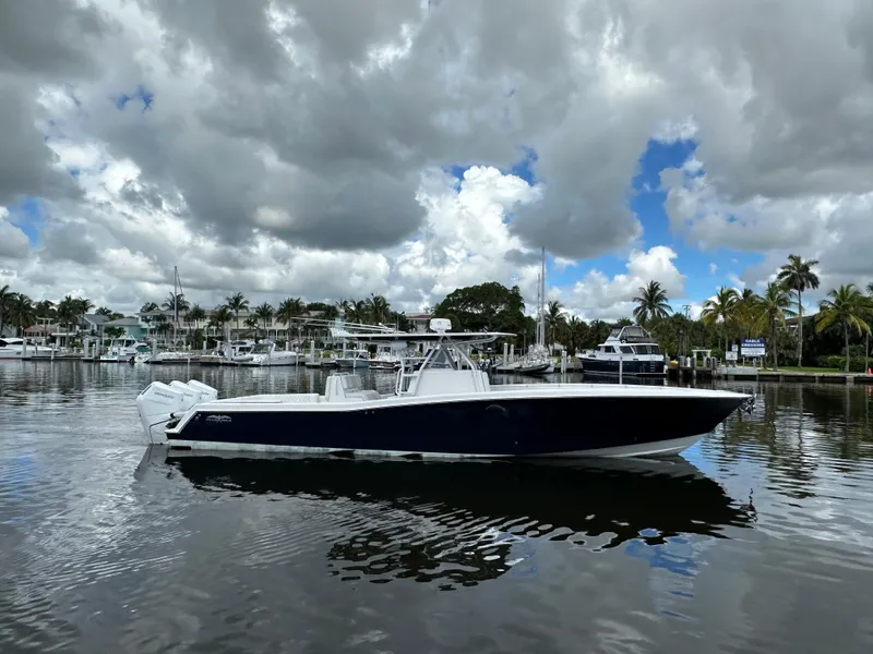 The Image of 2013 Invincible 42 Open Fisherman boat on calm water, cloudy sky background. - 0
