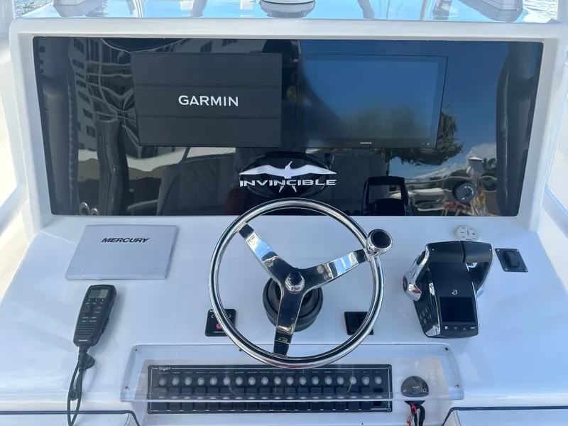Slide: The Image of Control panel of 2013 Invincible 42 Open Fisherman with Garmin display and Mercury controls. - 16