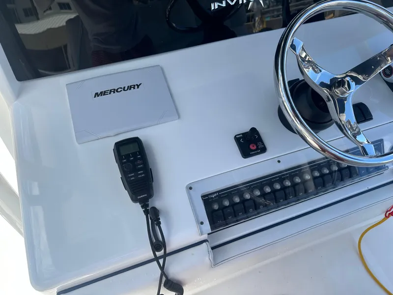 Slide: The Image of Invincible 42 Open Fisherman 2013 boat dashboard with Mercury controls and steering wheel. - 17